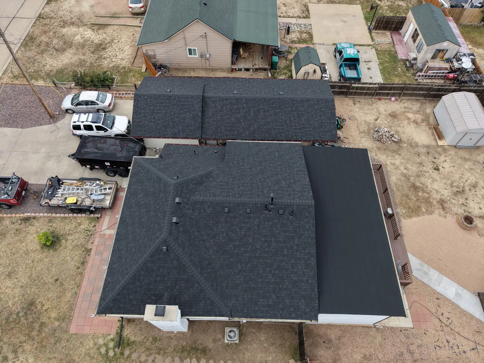 Overhead view of a charcoal hip roof and a low-slope flat section finished together